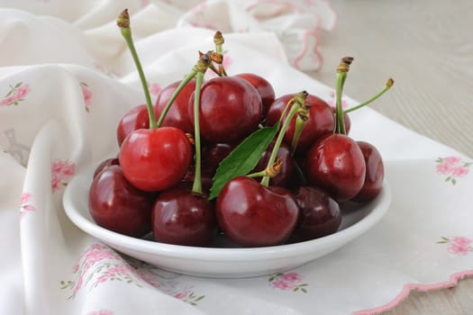 plate of ripe cherries on the table with a napkin