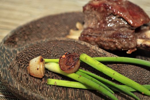 Roast red beef meat bbq bloc served on black plate with green chives