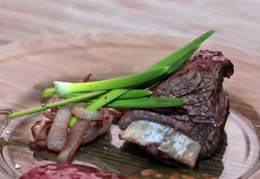 Roast red beef meat bbq bloc served on black plate with green chives