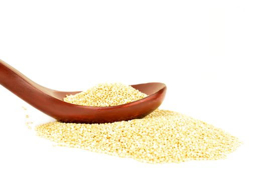 uncooked quinoa grain with wooden spoon on white background