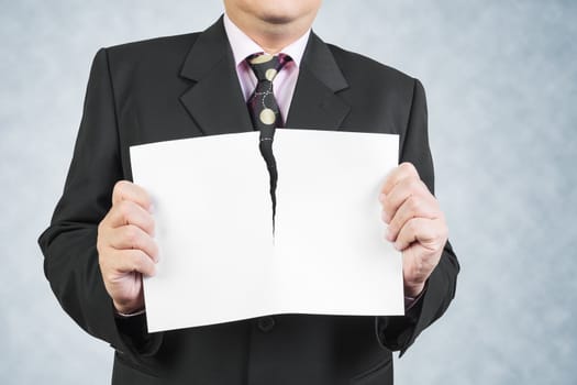 Businessman tearing sheet white paper on white background