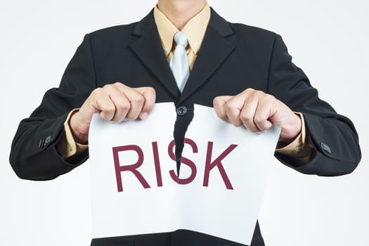 Businessman tearing sheet paper, risk management concept