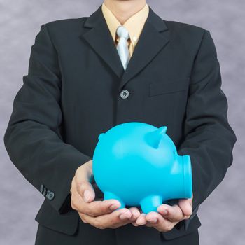 Businessman hand holding piggy bank on white background