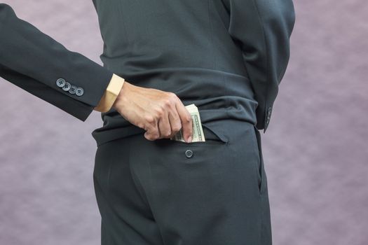 businessman hand put money to back pocket, finance corruption concept
