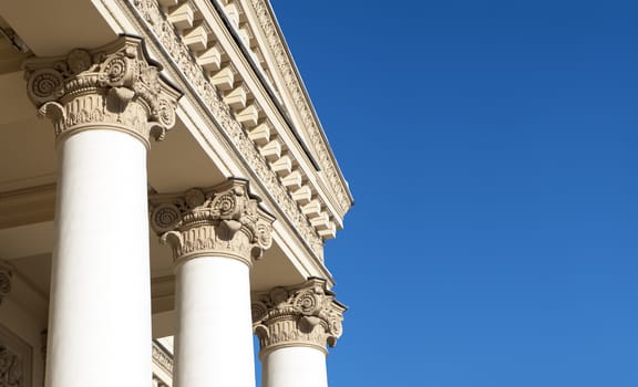 Ornately decorated Corinthian columns. Blue sky.