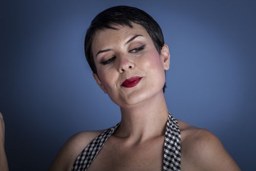 happy young woman with lollypop in her mouth on blue background