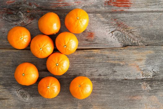 View from above of a group of delicious sweet juicy fresh clementines rich in vitamin C on a rustic wooden table with copyspace