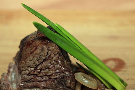 Roast red beef meat bbq bloc served on black plate with green chives