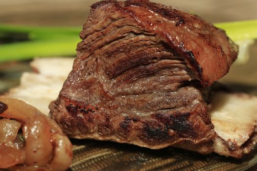 Roast red beef meat bbq bloc served on black plate with green chives