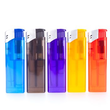 Row of vividly coloured plastic disposable lighters for smokers in red, yellow, two shades of blue and black isolated on a white background