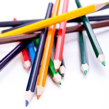 Bunch of sharpened wooden colourful pencil crayons in the colours of the spectrum or rainbow on a white background symbolising art and creativity