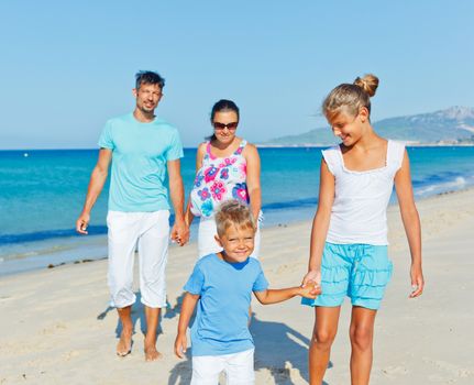 Family of four having fun on tropical beach