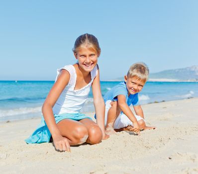 Two cute kids playing on tropical beach