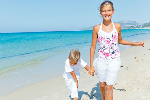 Adorable happy boy and girl runs along beach vacation