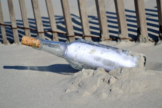 Bottle containing a message of help on a beach