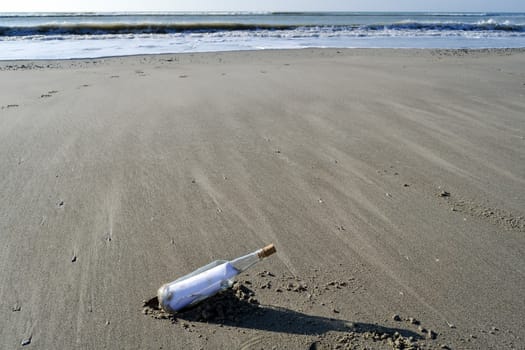 Bottle containing a message of help on a beach