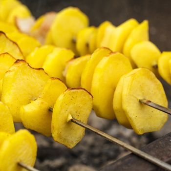 Roasted potato on the skewers with lard pieces