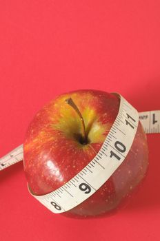 Measuring Tape Wrapped Around Red Apple as a Symbol of Diet