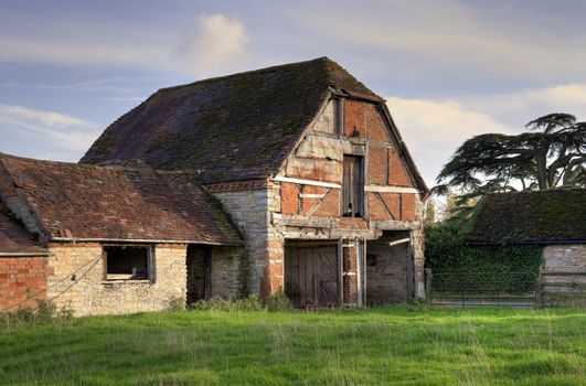 Dilapidated half-hipped Warwickshire barn, England.