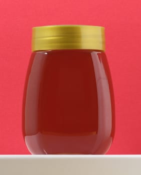 One Full Honey Jar on a Colored Background