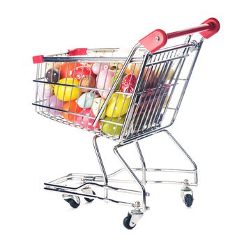 Shopping trolley with many decorative easter eggs on white