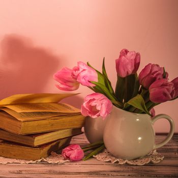 Poem still life with books and pink tulips