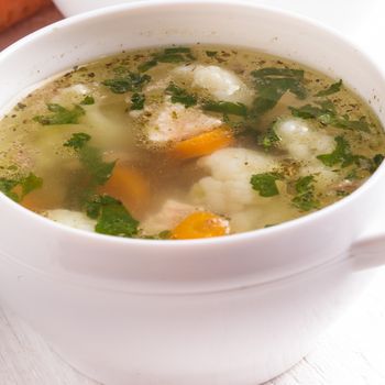 Chiken cauliflower and carrot soup in a white cup