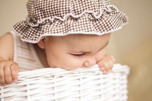 Eight month baby girl play with laundry basket