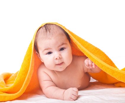 Three month baby under orange towel isolated on white