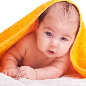 Three month baby under orange towel isolated on white