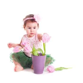 Adorable toddler girl with pink tulips, isolated on white