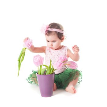 Adorable toddler girl with pink tulips, isolated on white