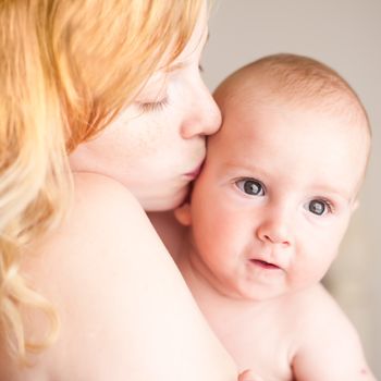 Mother kissing her baby, close up portraits
