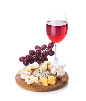 Plate with pieces of various types of cheese, grape and glass of wine, isolated on white