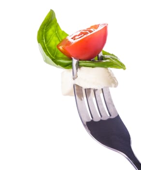 Caprese salad ingredients on the fork isolated on white