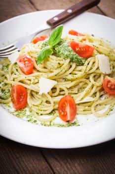 Spaghetti with green pesto, parmesan and cherry tomatoes