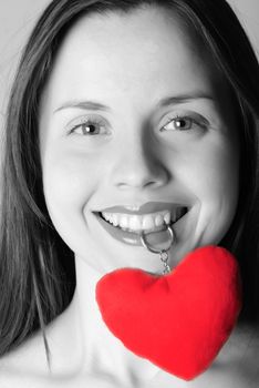 Girl's face with trinket heart in mouth