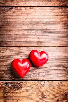 Two red hearts on old shabby wooden background with copy space