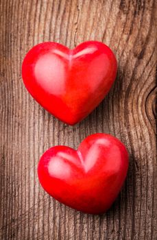 Two red hearts on old shabby wooden background