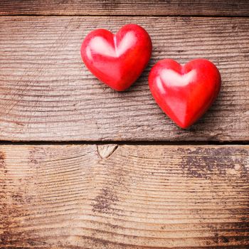 Two red hearts on old shabby wooden background with copy space