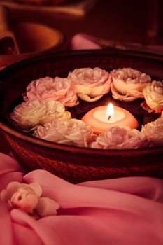 Spa relaxation - burned candle floating in rose water