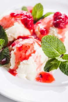 Vanill ice cream with strawberry jam and mint leaves