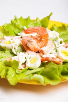 Salad with boiled shrimps, quail eggs and sauce