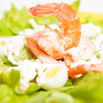 Salad with boiled shrimps, quail eggs and sauce