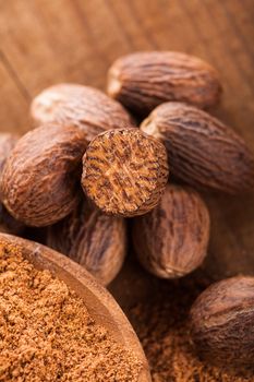 Ground nutmeg spice in the wooden spoon closeup