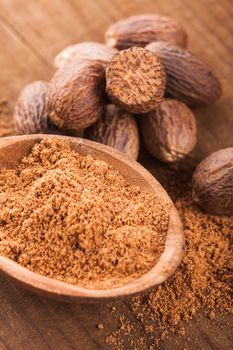 Ground nutmeg spice in the wooden spoon closeup