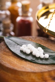 Homeopathy pills on the green leaf closeup