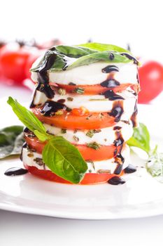 Classic caprese salad: tomato, mozzarella and basil leaves