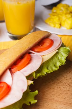 Breakfast with a sandwich, orange juice and scrambled eggs