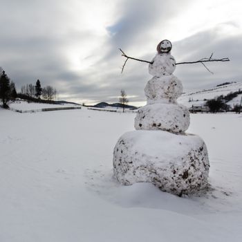 A snowman in the yard in village closeup